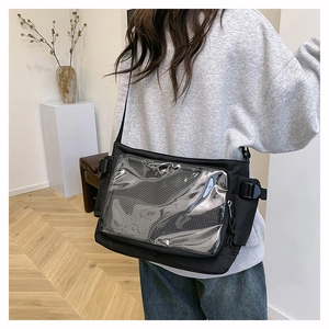 Detail of black crossbody ita bag with transparent window and side buckle on back of model