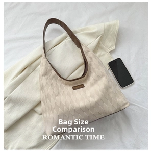 Detailed view of beige quilted tote bag showing large capacity compared to a smartphone