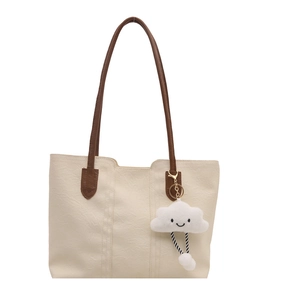 Minimalist off-white leather tote bag with brown straps and cute cloud charm accessory