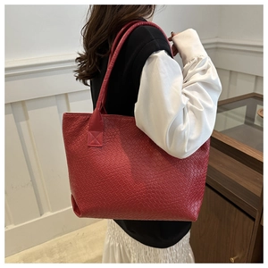Close-up of red large-capacity tote bag featuring intricate woven leather texture