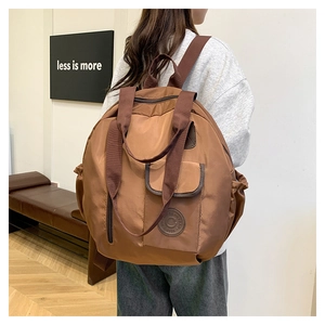 Brown water-resistant nylon travel backpack detail with functional pockets and logo