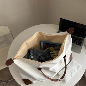 Large white nylon tote bag with brown leather trim showing spacious interior and accessories