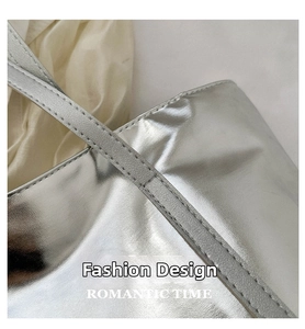Detail of silver laser tote bag showing reinforced handles and metallic mirror finish