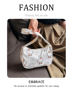 Detail of white canvas shoulder bag featuring cute cartoon duck print and text design