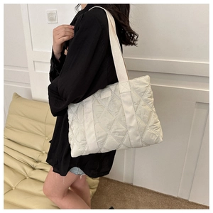 Detailed close-up of white quilted oxford tote bag with stylish wide woven shoulder strap
