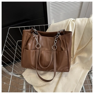 Detail of dark brown leather tote bag with silver chain straps in a shopping cart