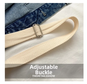 Dettaglio della fibbia in metallo regolabile sulla tracolla in tela beige della borsa denim