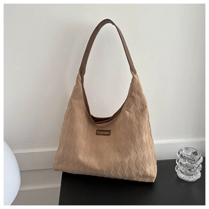 Detail of brown suede tote bag with quilted texture and fashion leather patch