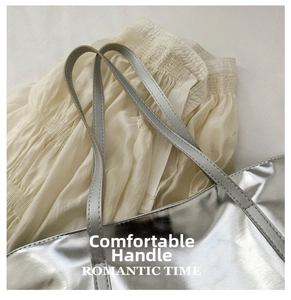Detail of silver mirrored tote bag showing reinforced handles and fine stitching quality
