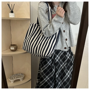 Detailed mirror selfie of a large striped canvas tote bag styled with a casual outfit