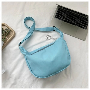 Detailed view of light blue corduroy crossbody bag with a cute white alpaca pendant charm