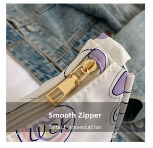 Close-up of smooth golden metal zipper on a white canvas bag with LUCKY print