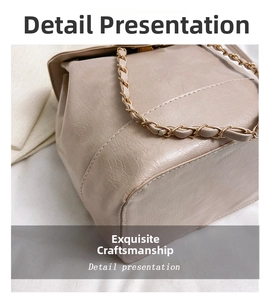 Detail of beige faux leather backpack showing uniform stitching and metal chain strap