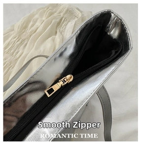 Close-up of the smooth golden zipper and metallic silver texture on this tote bag