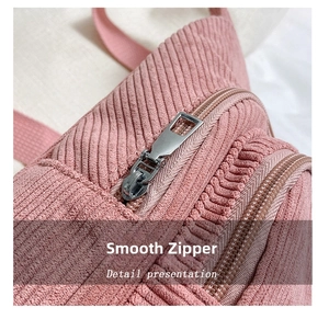Detail view of smooth silver metal zipper and neat stitching on pink corduroy bag