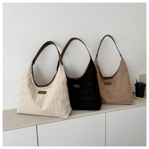 Detailed view of quilted tote bags in beige, black and khaki with faux leather straps