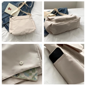 Detail of canvas messenger bag showing side pocket for phone and magnetic flap closure