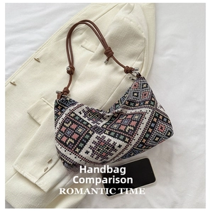 Detail of geometric pattern canvas shoulder bag with leather straps next to a smartphone