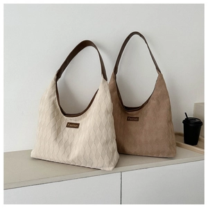 Close-up of quilted hobo shoulder bags in beige and brown with fashion label detail