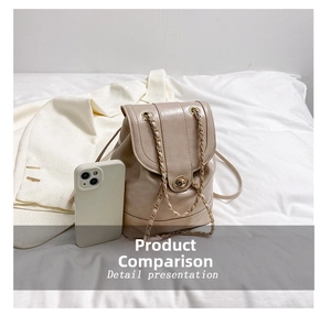 Detailed comparison showing mini beige backpack size against a smartphone for scale