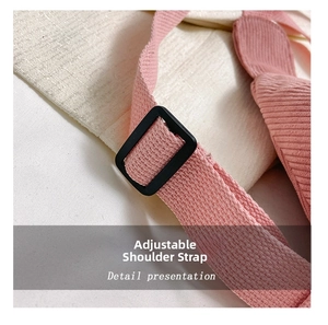 Detail presentation of pink woven shoulder strap with black adjustable plastic buckle