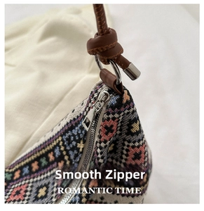 Detail of silver zipper and brown knotted strap on a colorful woven canvas shoulder bag