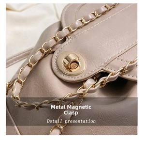 Detail of a beige leather shoulder bag featuring a round golden magnetic hardware buckle