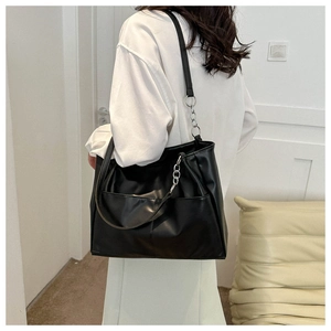 Close-up of black matte tote bag with silver chain strap on a model for daily commute