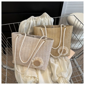 Detail of woven straw tote bags with sunflower charms in a metal shopping cart
