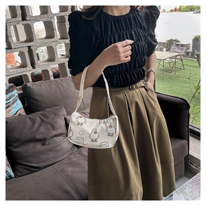 Detail of white underarm bag with cute cartoon duck print and Good Duck text