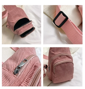 Detail view of pink corduroy waist bag showing zipper compartments and adjustable strap