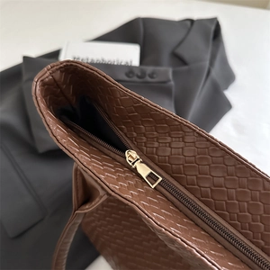 Brown woven tote bag for women showing top zipper detail and textured leather finish