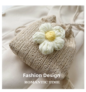 Detail of hand-woven beige bucket bag featuring 3D crochet flower and drawstring tassels