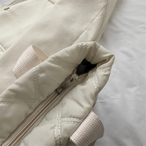 Cream quilted nylon tote bag with diamond stitching and smooth zipper closure detail