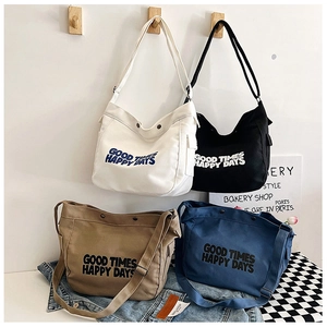Detailed close-up of large canvas crossbody bags with GOOD TIMES lettering and metal snap