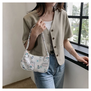 Close-up of white shoulder bag with cute rabbit print and sweet typography detail