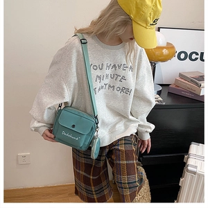 Green nylon crossbody bag with mini pouch and Dachshund print shown on a model