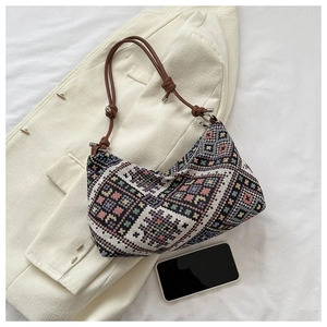 Close-up of geometric jacquard fabric and leather rope strap on ethnic crossbody bag
