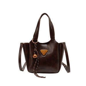 Retro dark brown bucket bag with top handles, crossbody strap, and golden bell charm