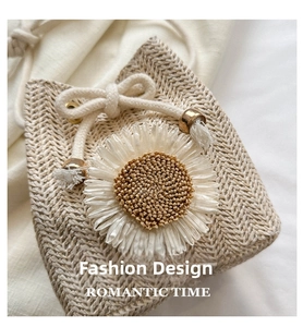 Detail of beige straw bucket bag featuring woven herringbone pattern and large white daisy