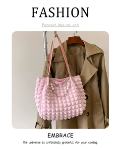 Close-up of pink bubble texture fabric on a tote bag with a silver chain and pearl strap