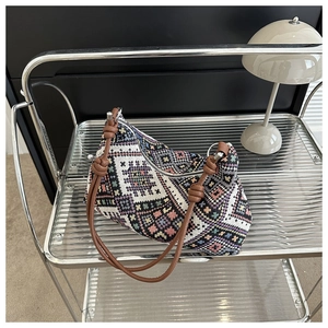 Detail of bohemian wool woven crossbody bag featuring colorful geometric patterns and leather strap