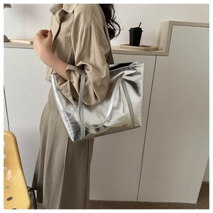 Detail of a large metallic silver tote bag with glossy wrinkled texture for daily commute