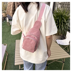 Pink corduroy waist bag with adjustable strap shown on model in outdoor camping scene