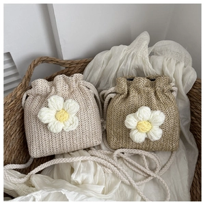 Close-up of woven bucket bags with large crochet flowers and rope shoulder straps