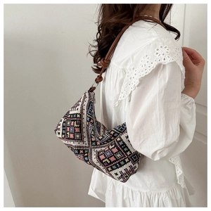 Detail of colorful woven ethnic pattern on shoulder bag with brown leather strap