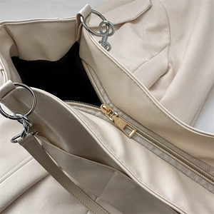 Creamy white faux leather tote bag with gold zipper and silver metal hardware details