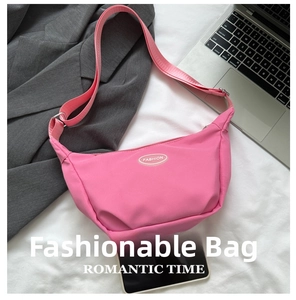 Pink nylon crescent shoulder bag featuring embroidered logo and adjustable strap detailing