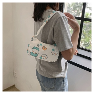 Detail view of white canvas shoulder bag with cute cartoon dog and cloud patterns