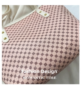 Macro shot of pink lychee leather texture with clover print and gold rivet details